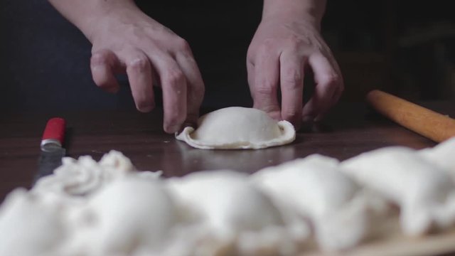Mujer armando empanada rellena de carne picada