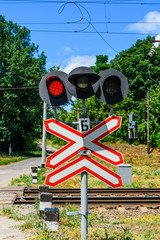 Railroad crossing sign and blinking semaphore in front of the railroad crossing