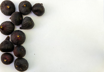 Fresh ripe sweet figs on white paper with copy space.