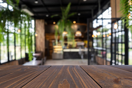 Empty wooden table of brown on front in blurred coffee shop background, image for presentation product