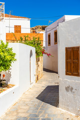 Traditional greek street with white houses on Rhodes island. Lindos village, Dodecanese, Greece.