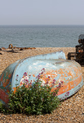 upturned boat on a beach with the sea in the background