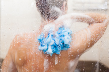 Fototapeta premium The young woman uses a shower in the bathroom of her house