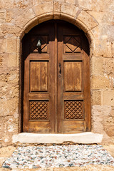 Fototapeta na wymiar Wooden door in traditional Greek house in historic village of Lindos on Rhodes island. Greece.