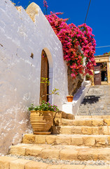 Traditional greek houses with spring flowers on Rhodes island. Lindos village, Dodecanese, Greece.