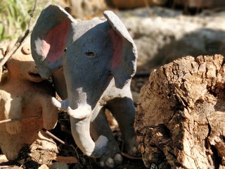 Clay animal in the garden with grass and stones surroundings