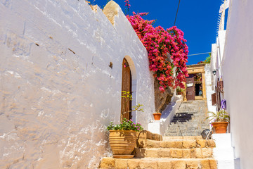 Beautiful Greek street with summer flowers in Lindos village. Rhodes island. Greece. © vivoo