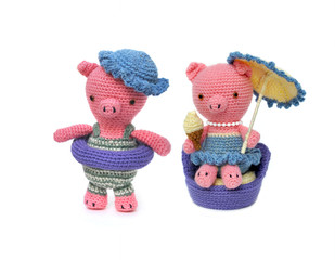 Two crocheted piglets on the beach