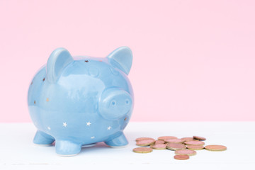 Blue piggy bank with coins, savings concept