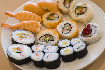 White plate full of sushi pieces