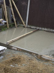 levelling wet cement on a shed base