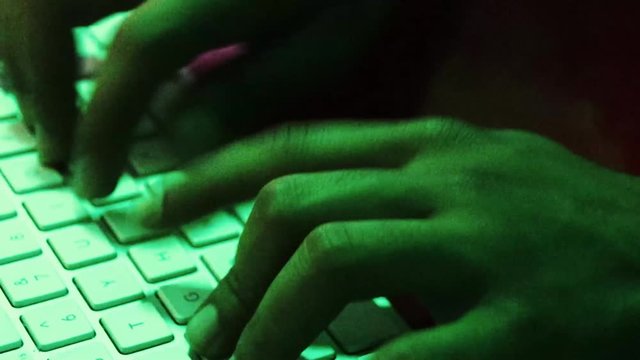 hacker taping on his keyboard during programmation and hacking process