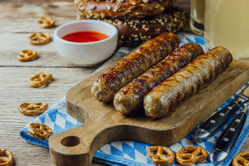 Rustic background for Oktoberfest or Bavarian specialties with white and blue fabric, beer glass and pretzels on wooden table. vintage toned