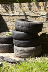 Fototapeta premium Stack of used tyres being used a plant pot