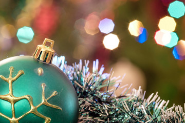 A large glass bowl with a pattern of snowflakes. In the background, blurred lights of a Christmas tree. Boke. Christmas toys in the Christmas tinsel.