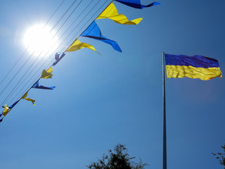 Ukrainian flag. Yellow-blue Ukrainian flag against the sky in the Dnipro. Ukraine's Independence Day. National symbol in the rays of the sun