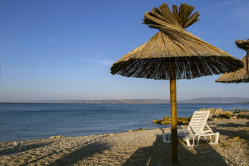 Nice view of beach Croatia. Crystal clear waters and beach umbrellas . European travel. 