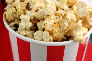 Popcorn in a striped box. Movie eating in theater