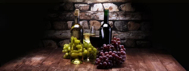 Papier Peint photo Vin Bouteille de vin rouge et vin blanc avec raisins et verres sur fond de bois