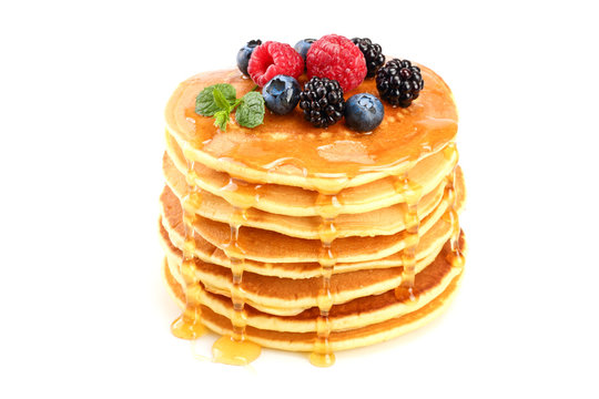 Pancakes stack with different berries and honey isolated on white background