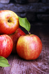 Ripe red apples and green apple on wooden background