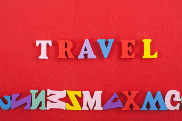TRAVEL word on red background composed from colorful abc alphabet block wooden letters, copy space for ad text. Learning english concept.