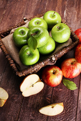 Ripe red apples and green apple on wooden background