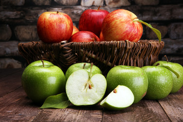 Ripe red apples and green apple on wooden background
