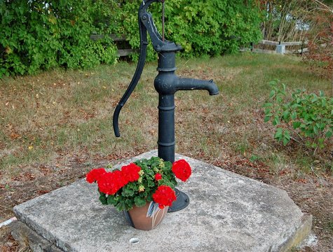 Vacker gammal vattenpump mitt i byn