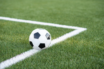 Traditional soccer ball on soccer field. black and White Soccer ball on green meadow