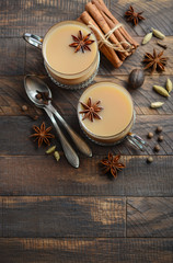 Indian masala chai tea. Spiced tea with milk in a vintage cups on the rustic wooden table.