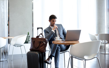 Businessman in airport business lounge with laptop