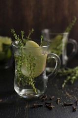 Herb tea with thyme, apple and cloves is on a dark background