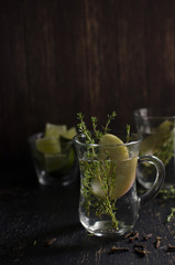 Herb tea with thyme, apple and cloves is on a dark background