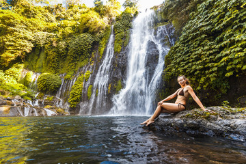 Fototapeta premium Young sexy woman looking at the waterfall Banyumala in jungles. Ecotourism concept image travel girl. Bali, Indonesia