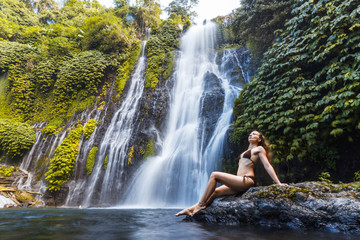 Fototapeta premium Young sexy woman looking at the waterfall Banyumala in jungles. Ecotourism concept image travel girl. Bali, Indonesia
