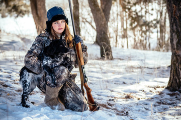 Girl hunter with binoculars in the forest, shows dog direction seeking mining. Concept of photo...