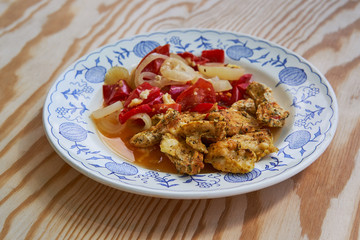 Roasted marinated spiced chicken strips with baked or roasted vegetables, sweet pepper, onion in own juice  served on rustic plate healthy food for reduction weight diet                              