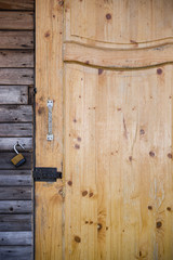 closeup of a wooden door with a lock in an old garden house.