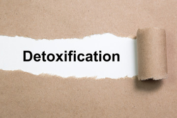 The word Detoxification appearing behind ripped paper.