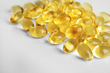 Cod liver oil pills on light background, closeup