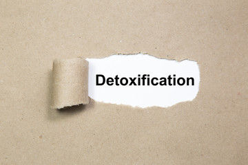 The word Detoxification appearing behind ripped paper.