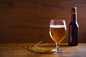 Glass and bottle of beer, ears of barley on wooden background. Ale. horizontal with copy space