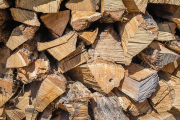 Cut wood, firewood for the winter. Cut logs fire wood and ready pieces of wood for heating wood. Lumber industry. Heating season, winter season. Renewable resource of energy. Environmental concept.