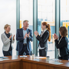 Business group clapping and smiling