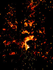 Naklejka na ściany i meble Flame of fire with sparks on a black background