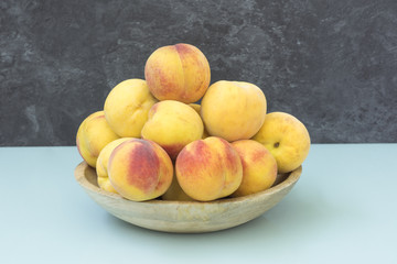 Frutero de madera con melocotones frescos