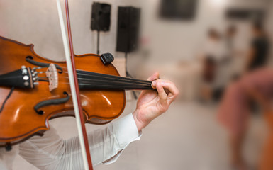 Violin playing viola musician. Man violinist classical musical instrument  fiddle playing on wedding.  Close up young fiddler dressed elegantly playing on wooden violin orchestra . Blurred soft focus 