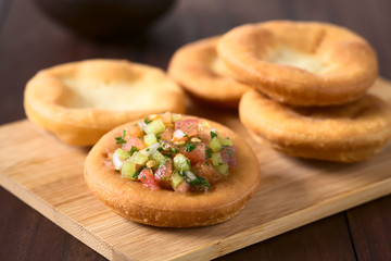Traditional Chilean Sopaipilla fried pastries, one served with Chilean pebre salsa, photographed...