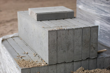 Road construction materials stacked on a pallet. Concrete curb for reinforcing the road shoulder.